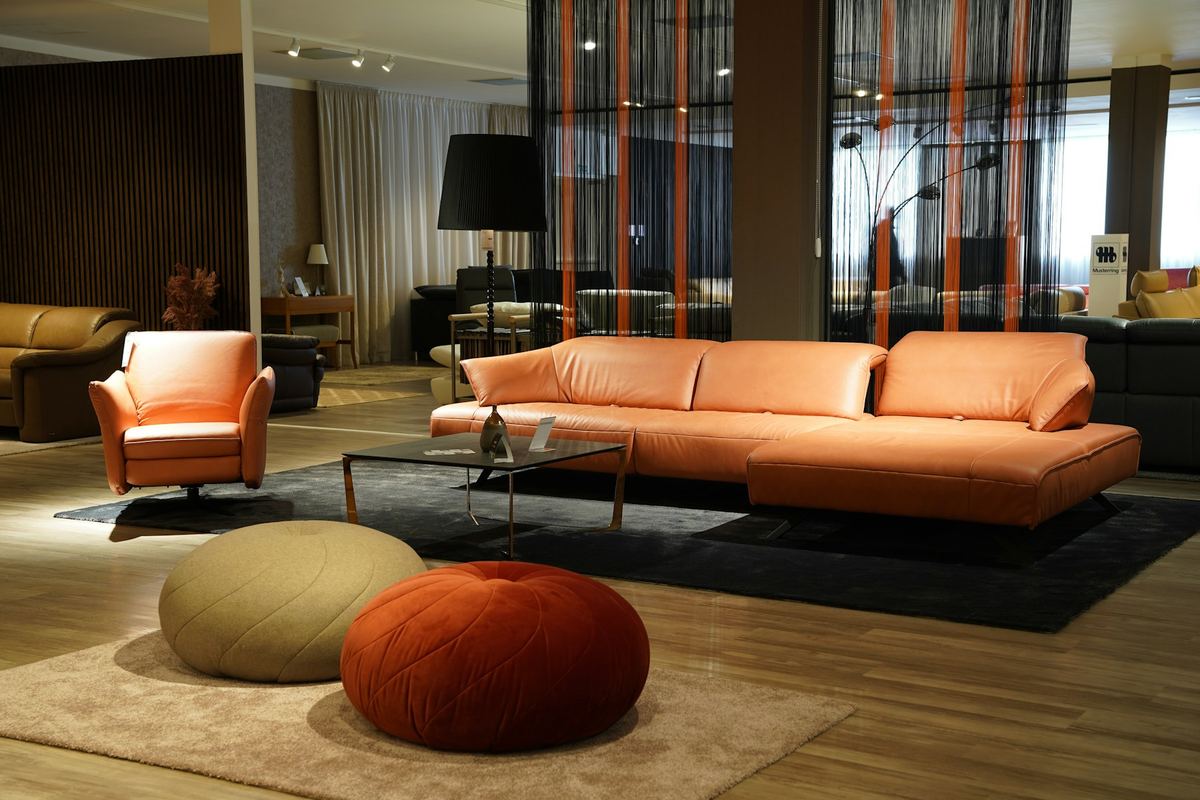Showroom met een amberkleurige bank en twee poefs